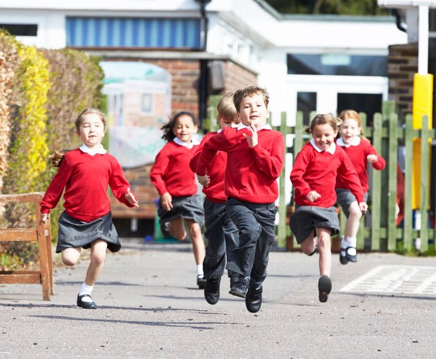 Elementary School Pupils Running In Playground